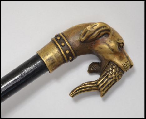 A vintage 20th century ebonised walking stick cane having a brass hunting themed top in the form of a hunting dog with a phea