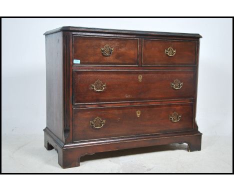 A Georgian style mahogany chest of drawers being raised on bracket feet having 2 short over 2 deep drawers with brass swing h