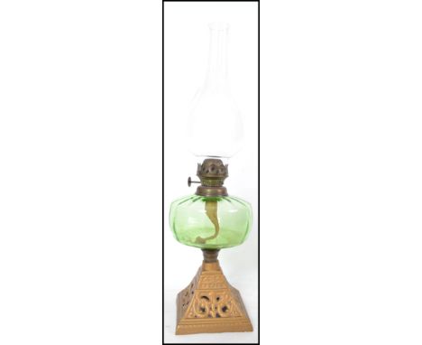 A Victorian gilt metal and green glass reservoir oil lamp complete with the glass flue