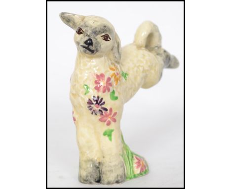 A 1930's Clarice Cliff for Newport Potteries model of a leaping spring lamb, with flowers around its neck, printed mark Wilki
