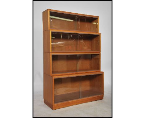 A mid century light mahogany 4 section stackling lawyers bookcase cabinet in the manner of Globe Wernicke / Lebus. Each secti