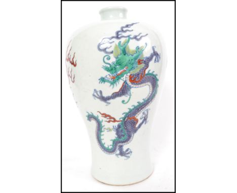 A believed 19th / early 20th century Oriental ceramic vase having a Meiping shape with Doucai detailing depicting a Dragon em