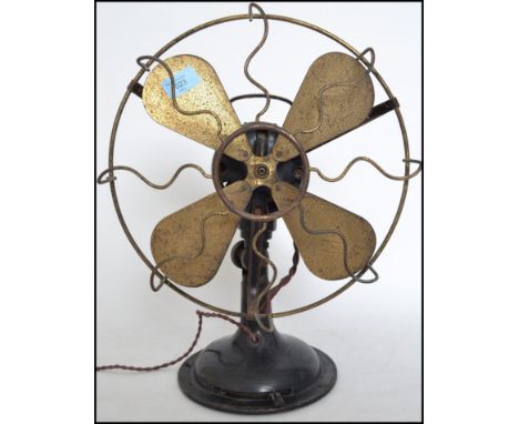 A vintage retro industrial factory mid century Italian made desk top fan. Metal blades behind wire work guard raised on a ped