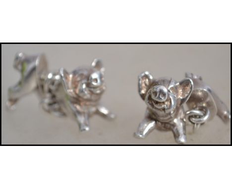 A pair of hallmarked silver cufflinks in the form of pigs the head and rear of the pig being joined by a chain with hallmarks