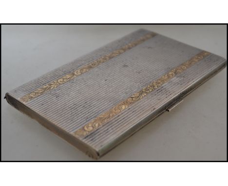 A continental silver 800 machined cigarette case having applied overlay gilt decoration