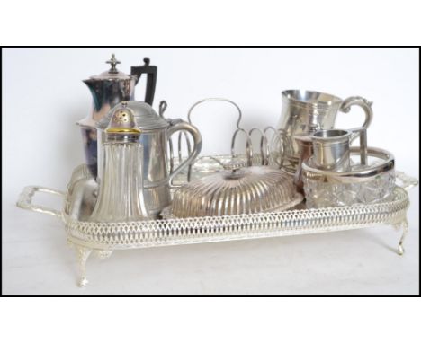 A collection of silver plated wares to include a large gallery tray, toast rack with glass dish to centre, condiments, part t