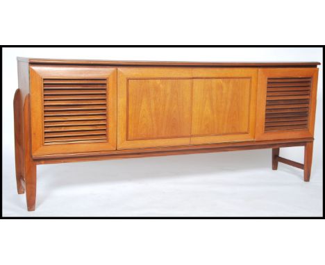 An unusual vintage retro 20th century teak wood Danish inspired sideboard consisting of two outer Louvre door cabinet with ce