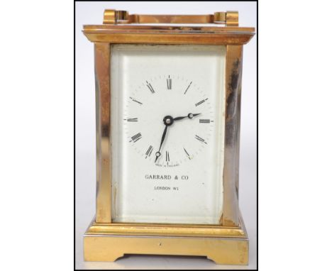 A 20th century brass cased carriage clock by Garrard & Co London W1. Open window escapement with handle atop. Roman numeral c