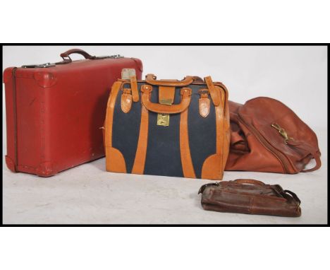 A vintage retro 20th century suitcase in red along with a vintage Gladstone bad, a leather holdall bag and another bag.