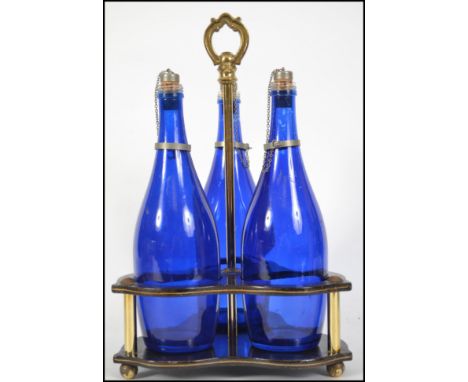 A vintage 20th century blue glass decanter set complete in a two tier ebonised holder with gilt handle atop.