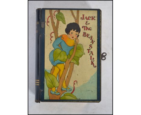 A vintage Jack and the Beanstalk money tin in the form of a book with lock and key to side.