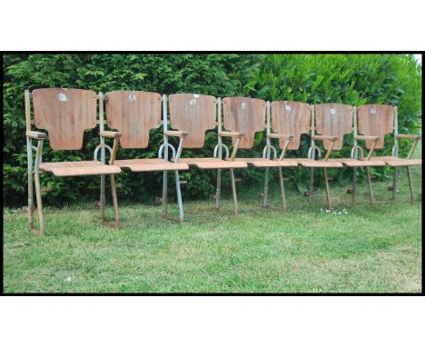 A set of seven vintage Industrial mid  20th century cinema - theatre chairs. Set on a metal tubular frame having wooden flip 