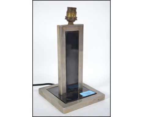 A 1930's Art Deco polished steel and ebonised metal table lamp. Of square form with two tone colourway having ebonised metal 