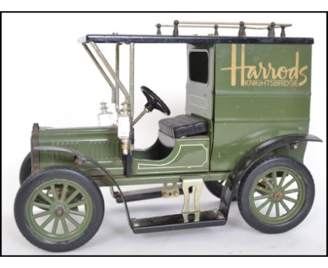 A vintage style tinplate large scale Harrods Ford van in traditional green colourway with Harrods decals to side. Measures 27