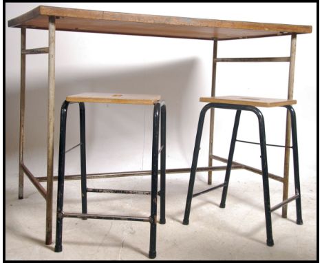 A mid century tubular metal School laboratory desk bench with 2 metal stools, both with panel wood seats