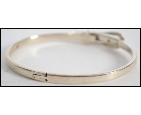 A ladies 20th century silver bangle in the form of a belt ( see illustrations ) Measures 6cms wide and weighs 16.5 grams.