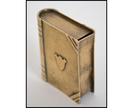 A vintage early 20th century believed trench art vesta / lighter in the form of a book having hidden section revealing a ligh