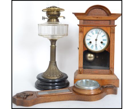 A late 19th century oil lamp together with an eight day wooden cased mantle clock and a 20th century barometer. Measures 60cm