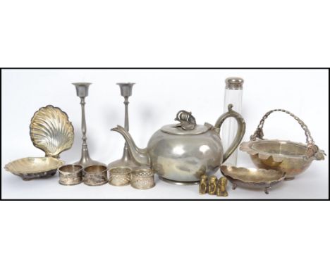 A collection of silver plated wares to include glass phial, teapot, clam salt, napkin rings, candlesticks etc