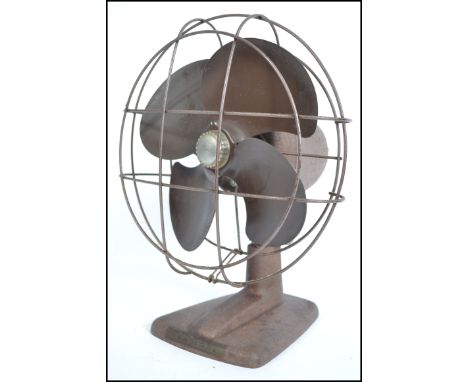 A vintage mid 20th century industrial metal desk fan having wired cage to front with notation for Kenmore to base.