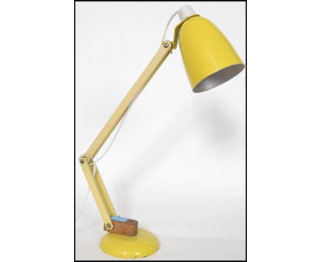 A retro mid century Terence Conran Mac Lamp in yellow having bell shaped shade and terraced base