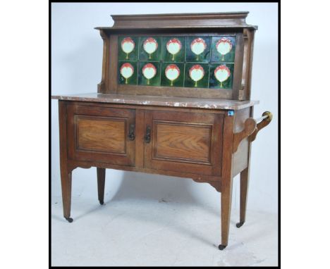 An Edwardian Art Nouveau oak and tile top marble washstand. The cabinet with twin doors having squared legs with marble stand