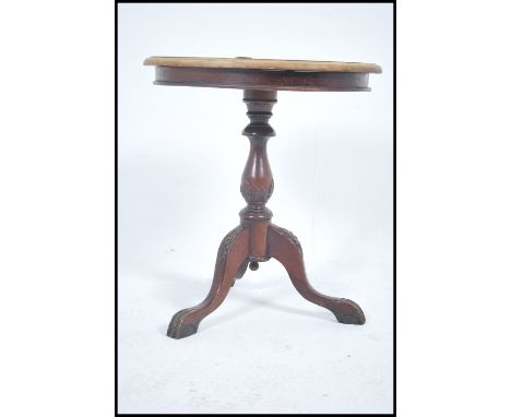 A Victorian mahogany tripod wine table raised on a splayed leg base, turned column with circular top having applied tavern nu