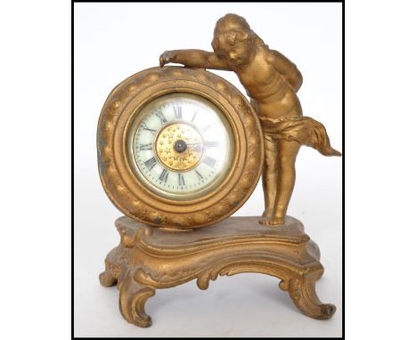 A late 19th century gilt cast metal desk clock of a cherub raised on socle base fitted with a British United Clock drum movem