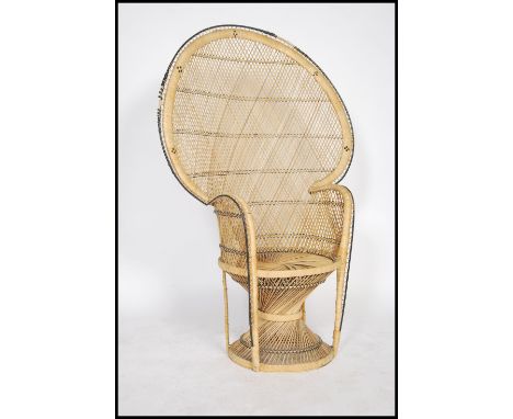 A vintage 20th century cane wicker rattan weave conservatory chair, having a peacock fan back with pierced arms and box base.