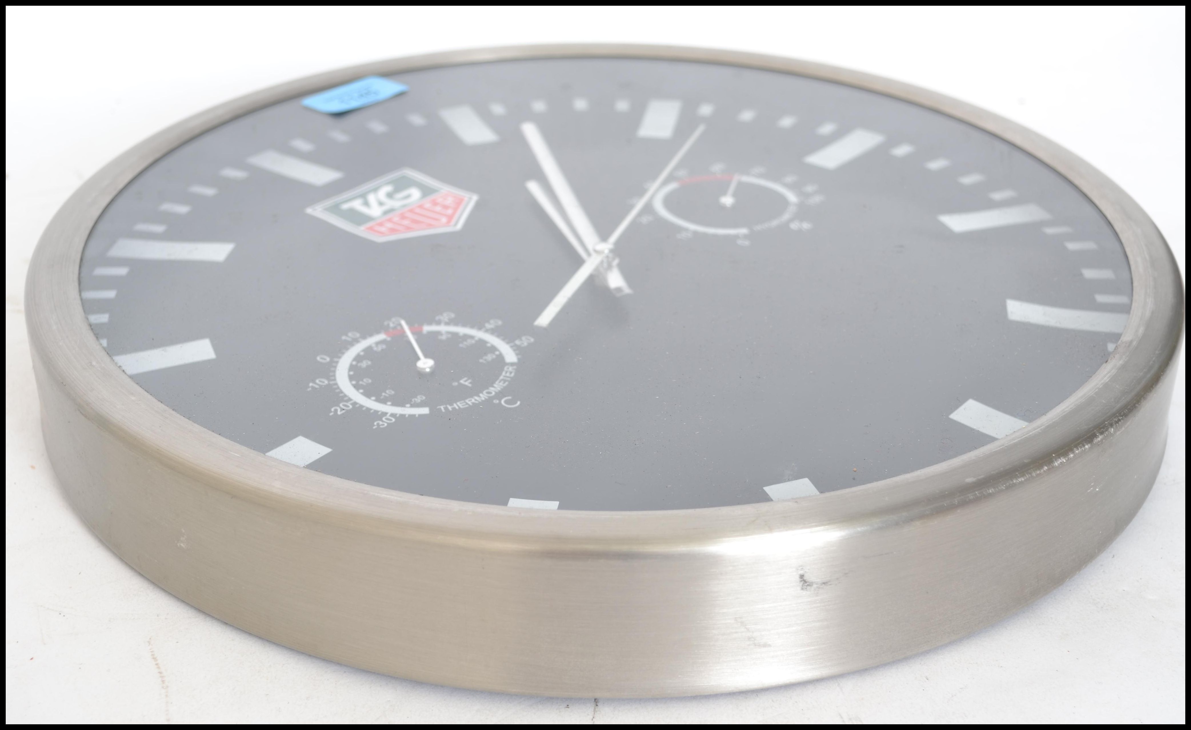 A reproduction Tag Heuer wall clock with black dial and baton numerals