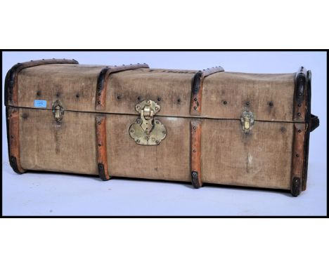 An early 20th century canvas and wooden bound steamer trunk having a hinged centre with brass fittings