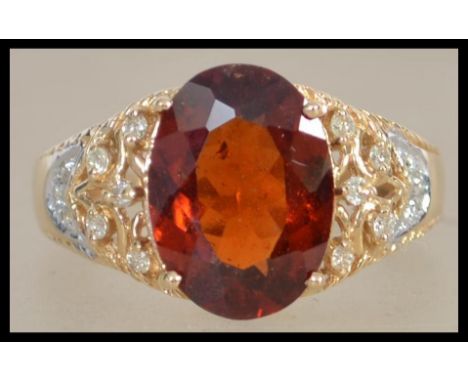 A yellow metal ladies ring set with a large central fire opal of approx 3ct's and flanked by diamond shoulders.