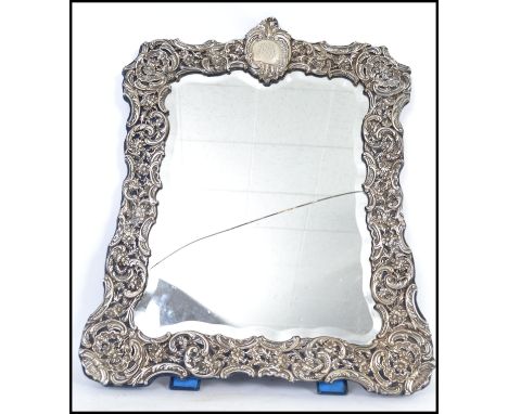 A stunning Edwardian large silver hallmarked rectangular easel mirror. The mirror of rococo form with monogram cartouche pane