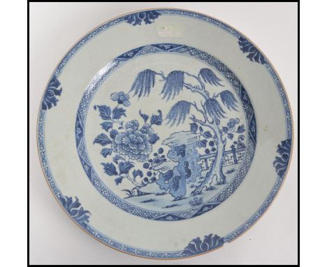 A believed 18th century Oriental blue and white ceramic plate, depicting a garden court view with trees and flowers. Measures