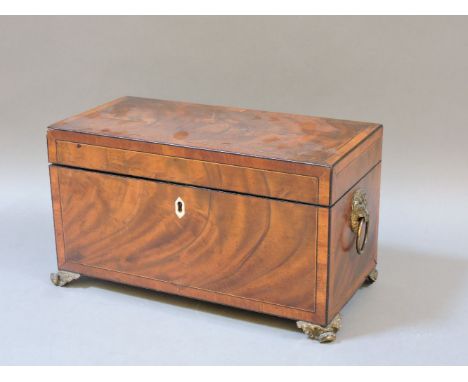 A George III mahogany boxwood and ebony strung tea caddy, with cast lion mask handles and feet, 31cm wide