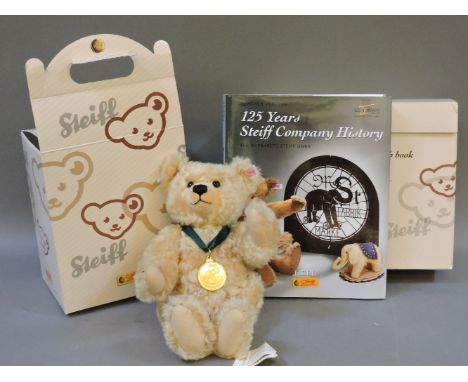 A small cream Steiff mohair teddy bear, in box with 125 Years of Steiff Company History Book