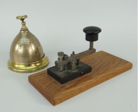 VINTAGE MORSE CODE TAPPER / BRASS RECEPTION DESK BELL the tapper on a wooden stand, the bell possibly fashioned from artiller