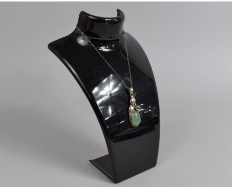 A Silver Mounted and Jade Pendant, Having Central Oval Jade Cabochon Housed in Leaf Motif Surround, on Silver Chain 