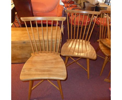 A set of four Ercol style walnut stick back chairs with shaped seat, raised on tapering supports joined by x stretchers 