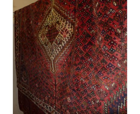 A fine south west Persian Qashqai carpet 302cm x 217cm triple pole medallion with repeating petal motifs on a terracotta fiel