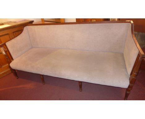 A Regency mahogany three seater sofa, upholstered in light grey fabric, the arms and legs carved with reeded detail 