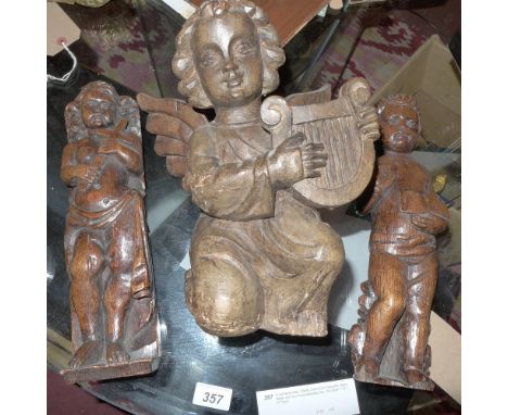 Two 19th century carved wooden furniture fittings in the form of a boy and girl together with a carved wooden angel playing s