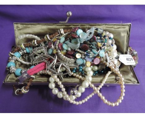 A beaded evening bag containing a selection of costume jewellery including a white metal bangle stamped 925