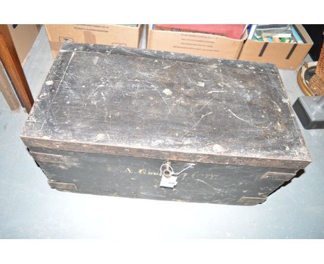 A rectangular black painted wooden box with hinged cover and metal bindings, inscribed A. Goodall (WWI Army Box).