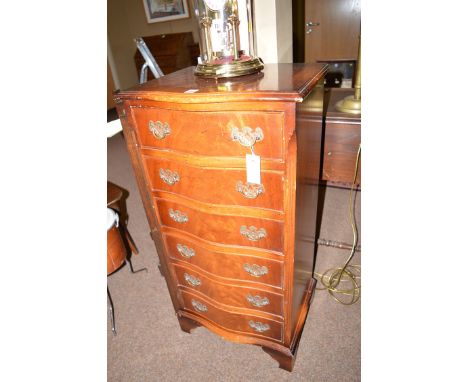 A reproduction mahogany serpentine front chest of six drawers, raised on bracket feet.