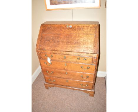 A 19th Century oak bureau, the fall-flap opening to reveal pigeon holes and central cupboard door, four long graduated drawer