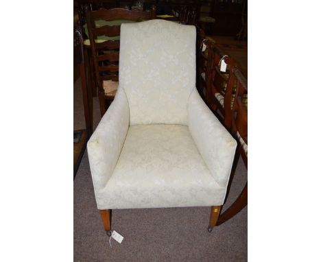 An easy armchair upholstered in light green floral material, raised on square tapered legs.