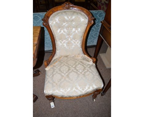 A lady's Victorian carved and stained walnut dressing chair, the shaped back with exposed and carved framework, the seat and 