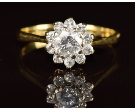 An 18ct gold ring set with a diamond of approximately 0.6ct surrounded by diamonds,&nbsp;3g, size N