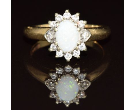 A 9ct gold ring set with an opal surrounded by diamonds, 3.2g, size K